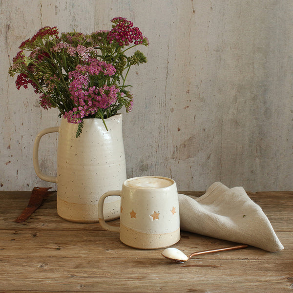 White pitcher jug filled with wildflowers next to our white star mug
