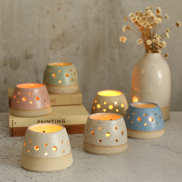 6 pastel tealights lit with candles