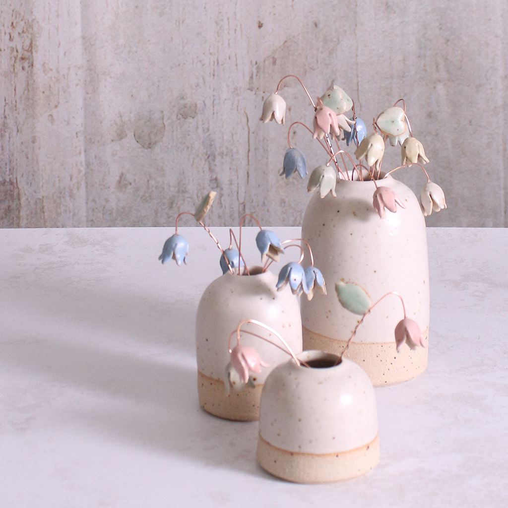 Handcrafted ceramic drop flower stems with soft glazes displayed in an off-white vase. Each flower features a flexible copper wire stem for easy adjustment.