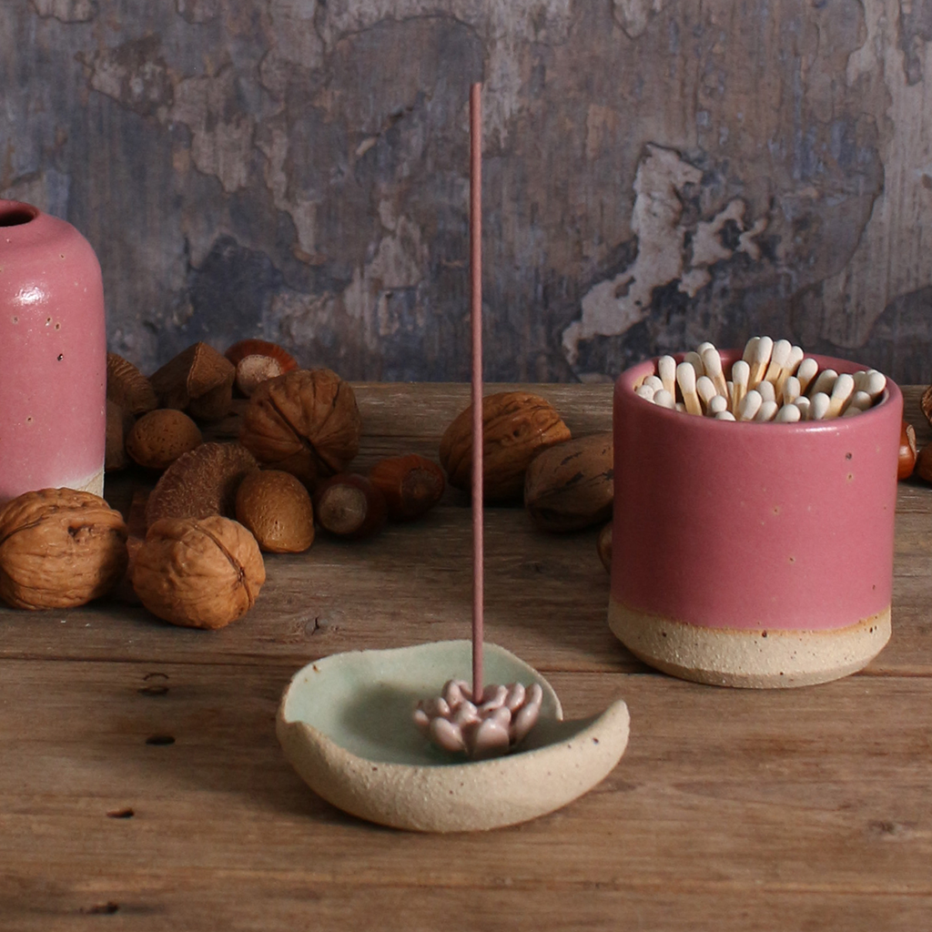 Lily Pad Ceramic incense holder with incense stick on a wooden surface with nuts and another ceramic container.