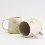 Two Aster mugs, one on its side