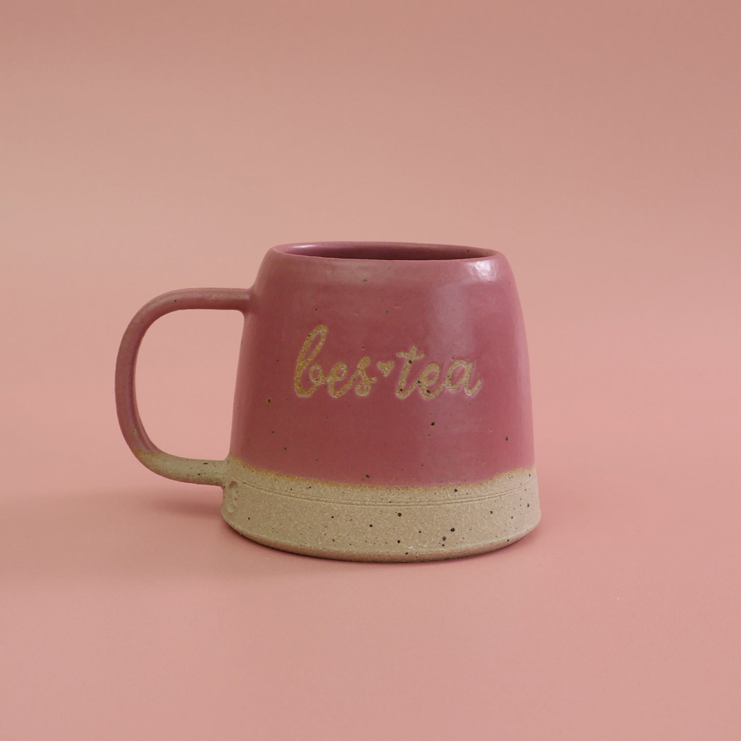 Pink ceramic mug with 'bestea' text on a pink background