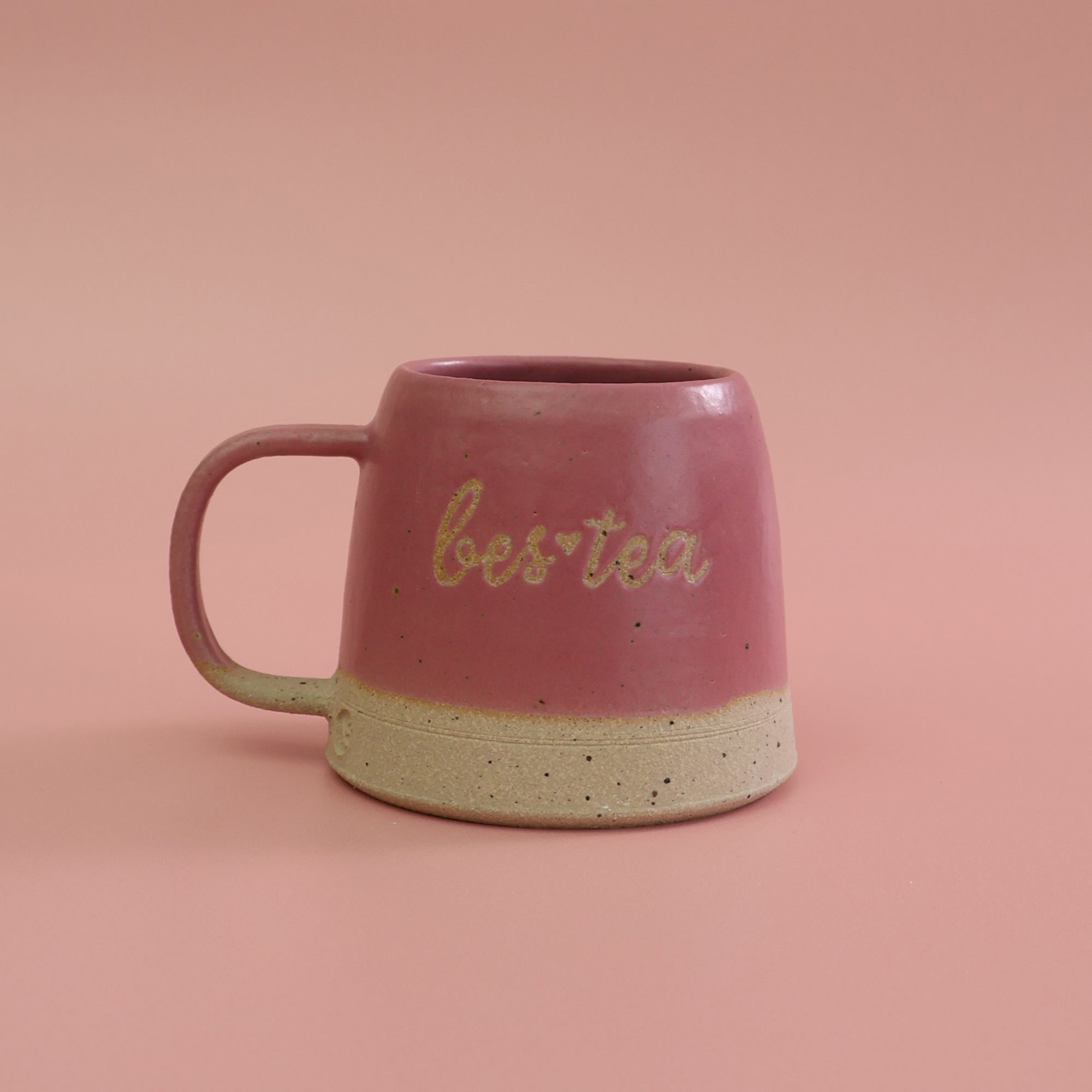 Pink ceramic mug with 'bestea' text on a pink background