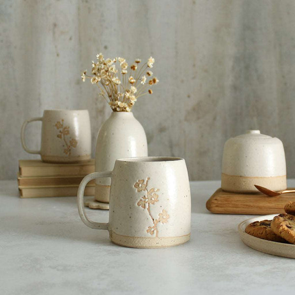 Cherry Blossom mug in front of white ceramics table setting