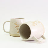 Two Cherry Blossom mugs, one on its side