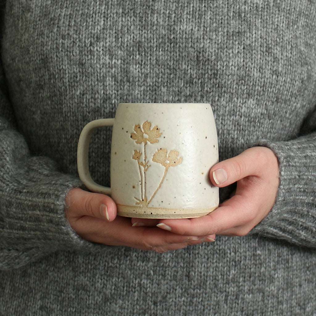 Hands holding Cosmos mug