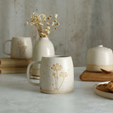 Cosmos mug in front of white ceramics table setting