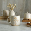 Cosmos mug in front of white ceramics table setting