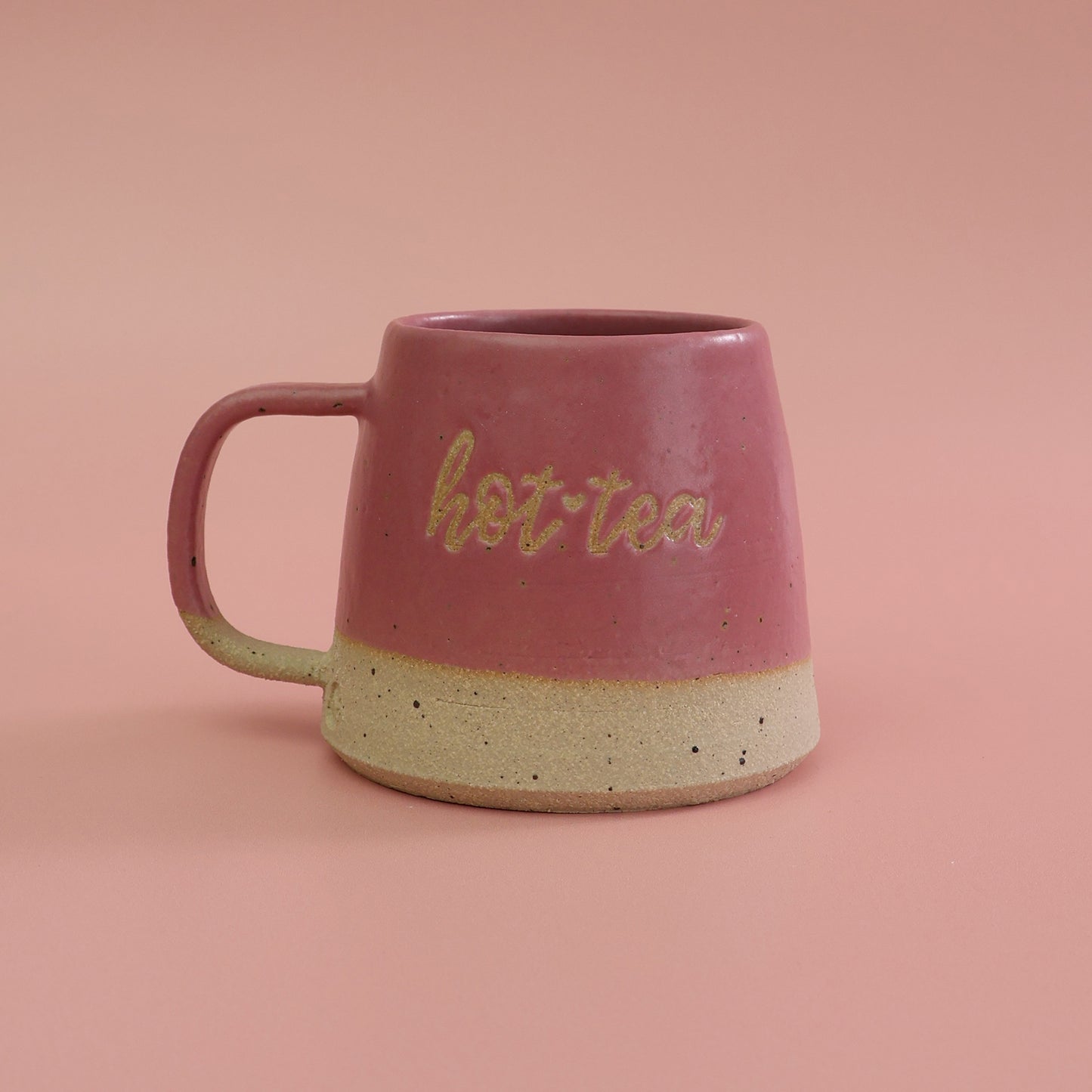 Pink ceramic mug with 'hot tea' text on a pink background handmade in the UK by Habulous Ceramics 