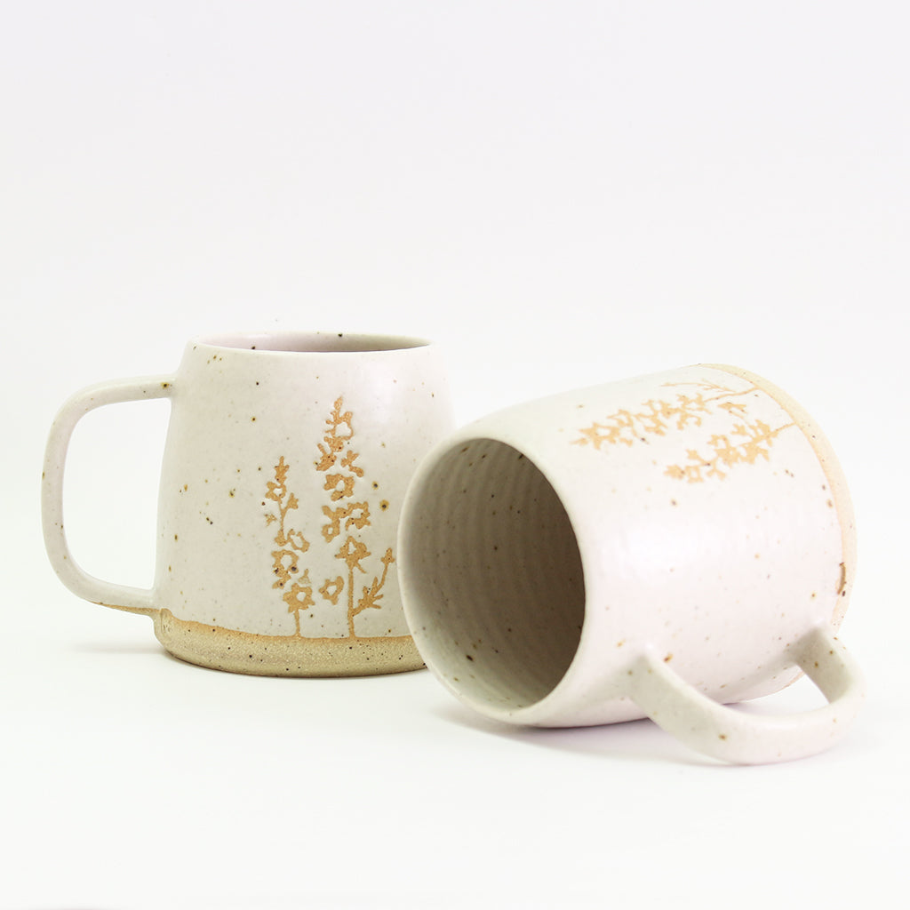 Two Larkspur mugs, one on its side