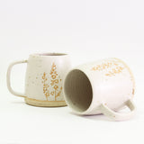 Two Larkspur mugs, one on its side