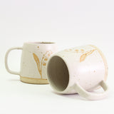 Two Lily of the Valley mugs, one on its side