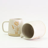 Two Narcissus mugs, one on its side
