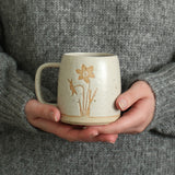 Hands holding Narcissus mug