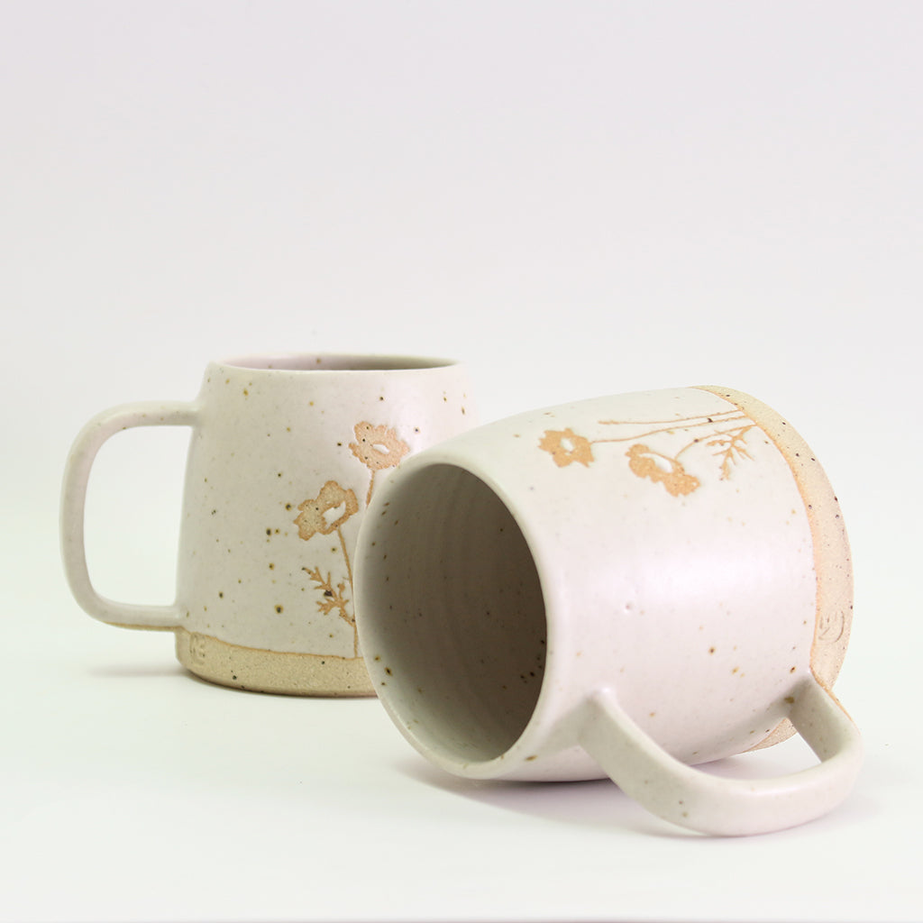 Two poppy mugs, one on its side