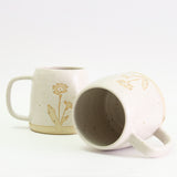 Two Primrose mugs, one on its side