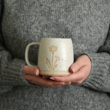 Hands holding a Primrose mug