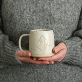 Hands holding Snowdrop mug