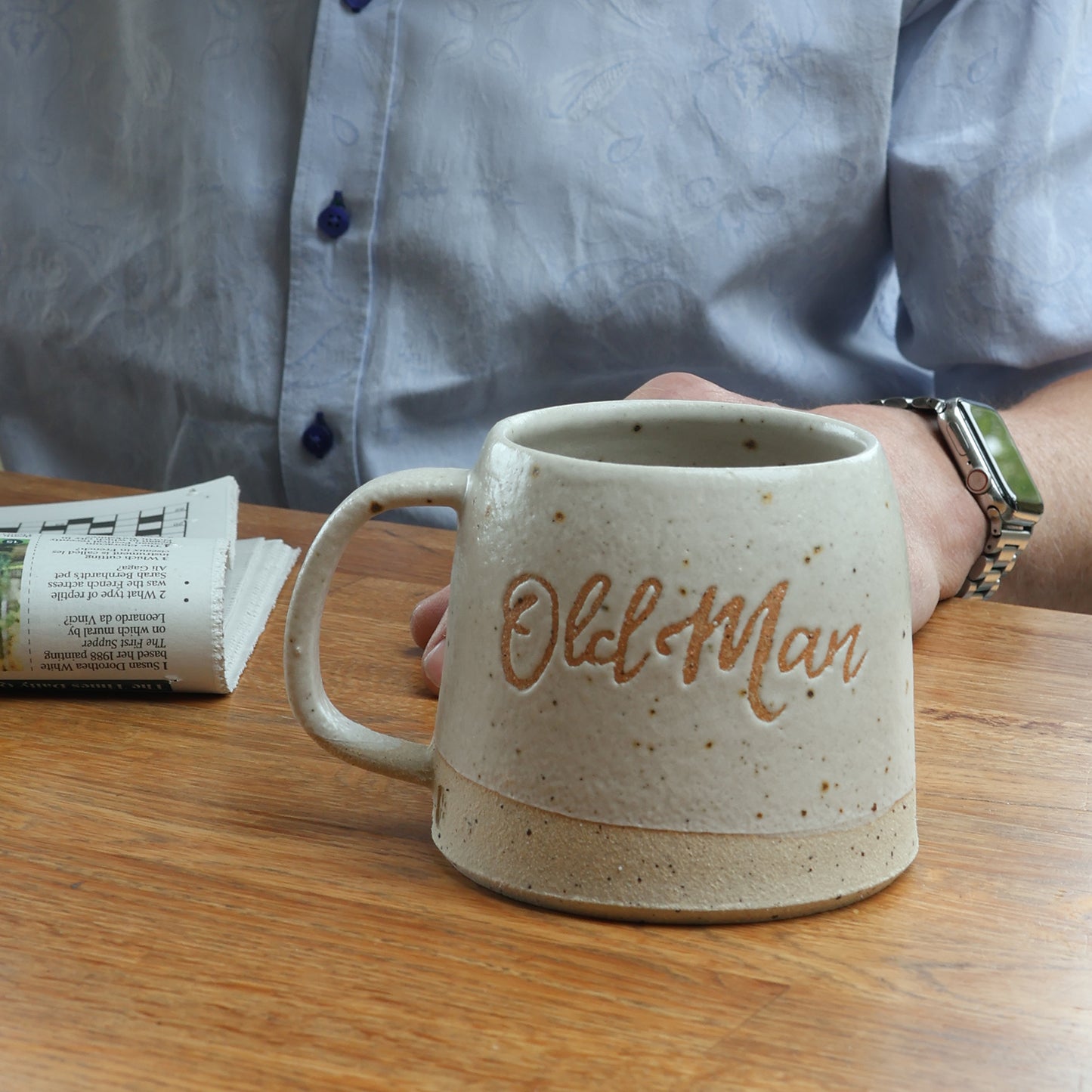 Handmade ceramic mug personalised with the words old man. the mug is on a wooden table