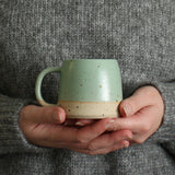 Hands holding mint green Small Stoneware Mug