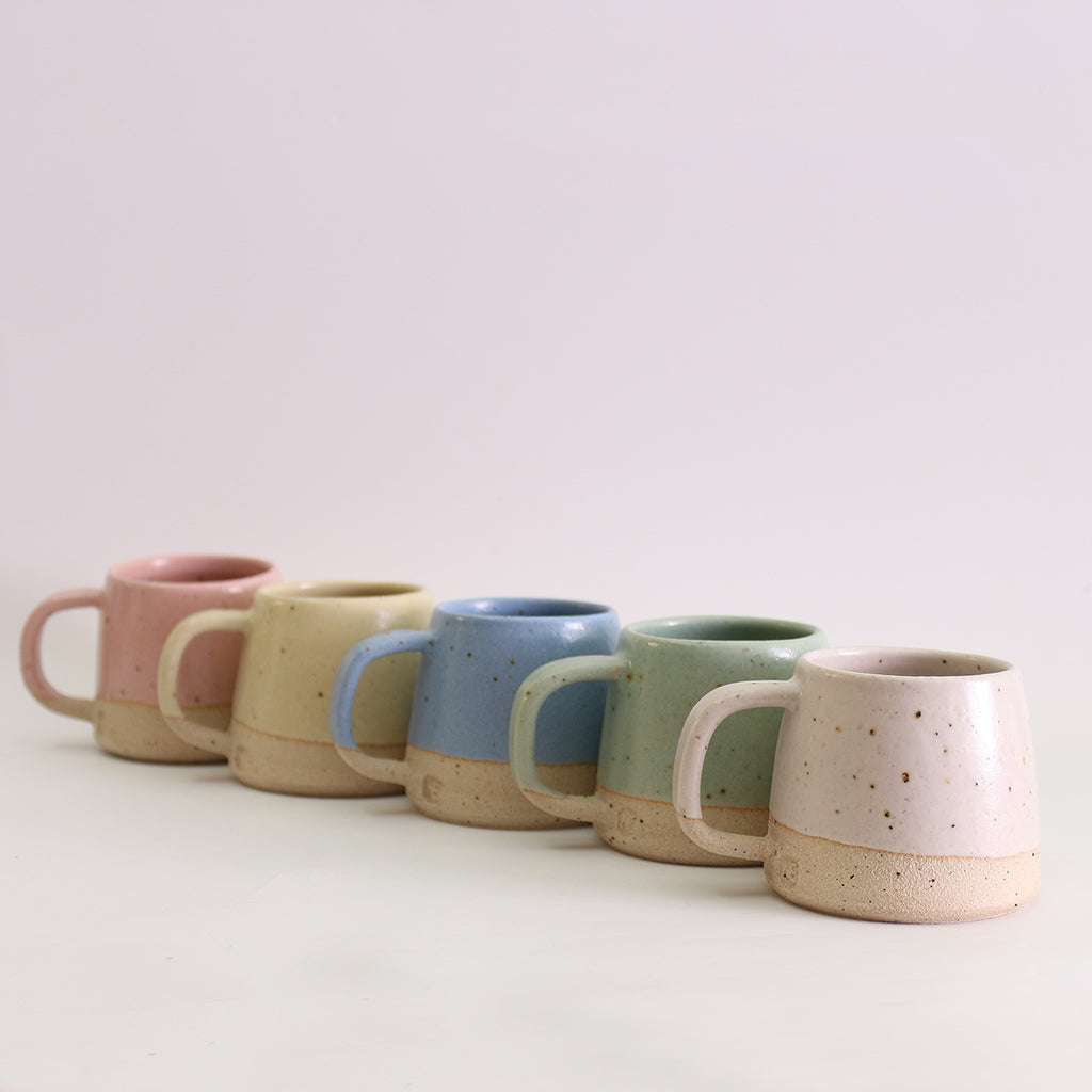Row of 5 coloured pastel small mugs showing handles and makers stamp