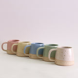 Row of 5 coloured pastel small mugs showing handles and makers stamp
