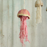 Decorative jellyfish ornamental hanging with pink curly wool tentacles in front of  a textured wall background - handmade by Habulous