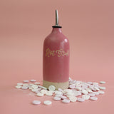 Pink bottle labeled 'Hot Stuff' with love heart sweets and on a pink background