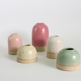 Set of five ceramic vases in pastel colors on a white background