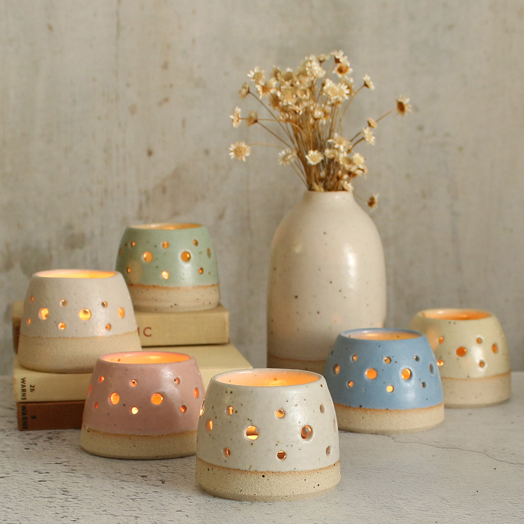 Set of lit pastel tealight holders