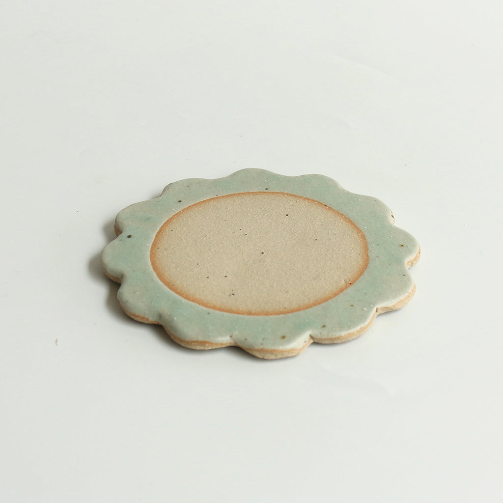 Close up of flecked stoneware and mint green glazed petals