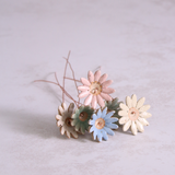 Several handmade ceramic daisy flower stems in different pastel glazes, creating a colourful ceramic bouquet.