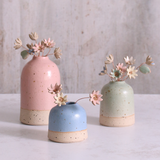 Set of three pastel ceramic daisy flower stems in handcrafted pink, blue, and green vases – unique handmade ceramic home decorations by Habulous