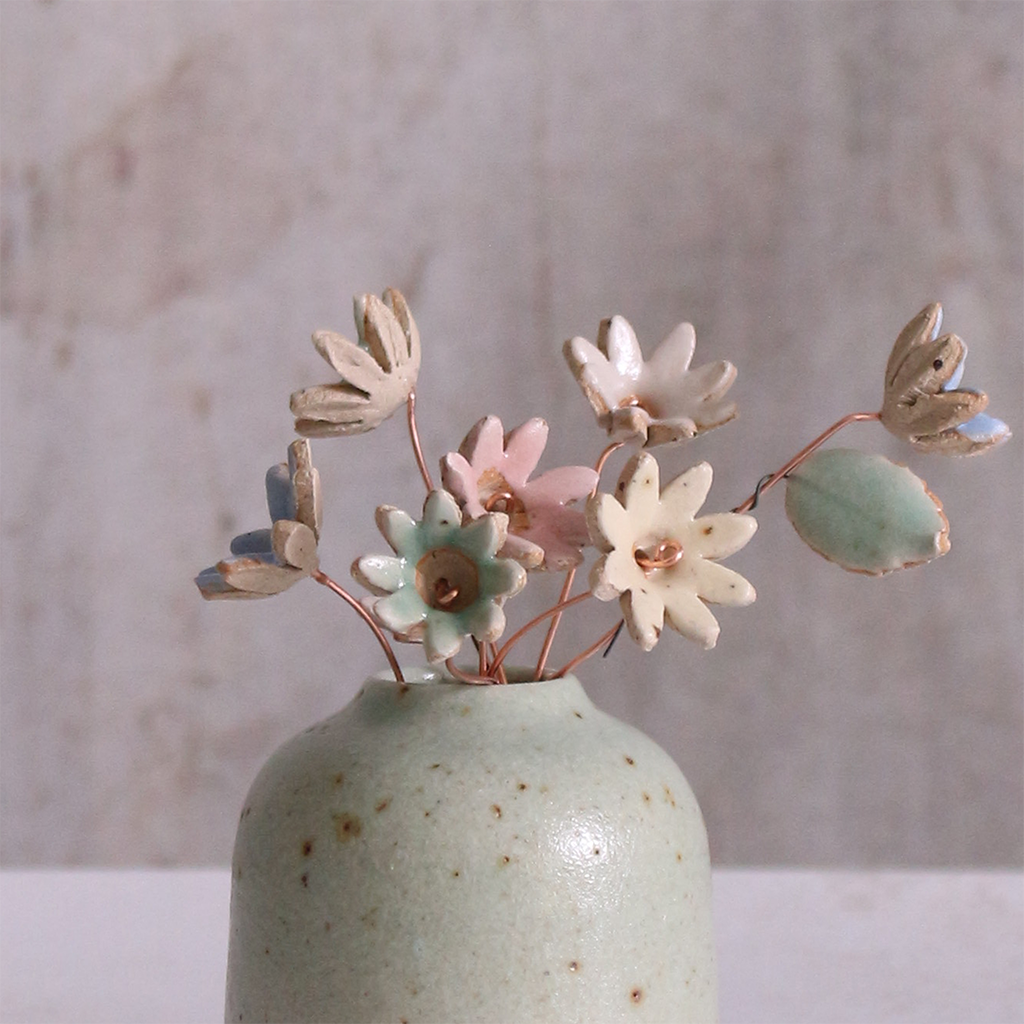 Pastel ceramic daisy flower stems displayed in a handcrafted green speckled vase – artisan home décor by Habulous