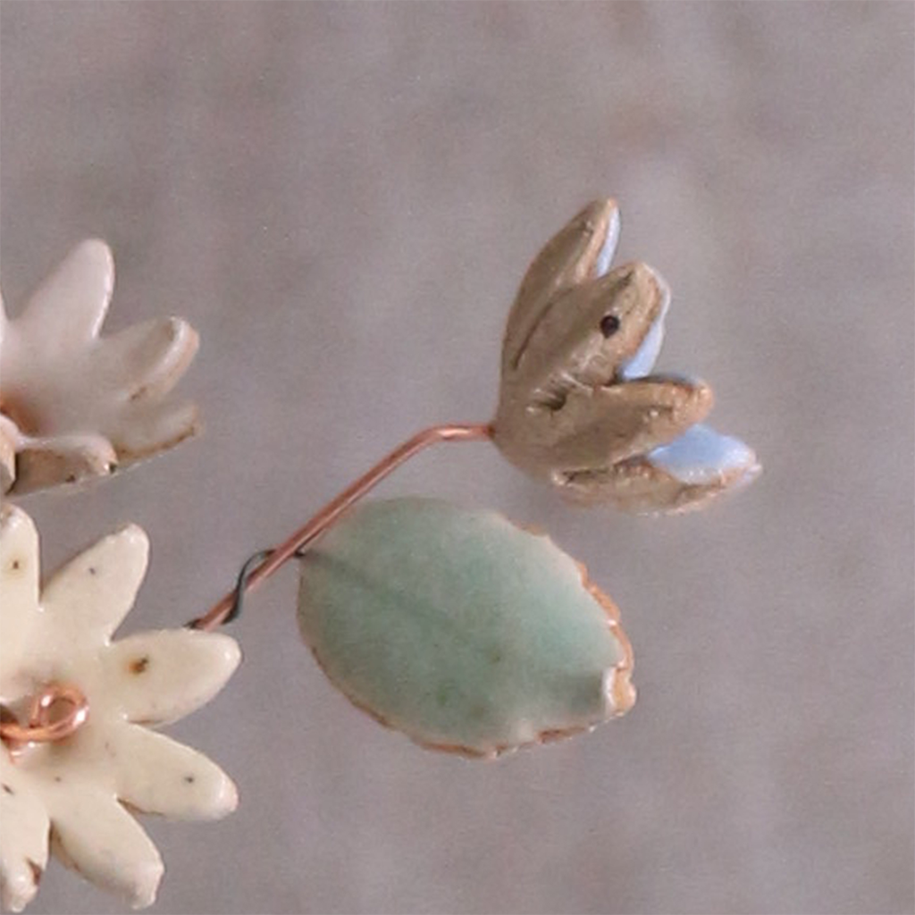 Close-up of pastel ceramic flower stems with a ceramic leaf attached, they're on copper wire stems – individually handcrafted floral home accessories from Habulous