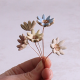 Pastel ceramic daisy flower stems displayed in a handcrafted green speckled vase – artisan home décor by Habulous