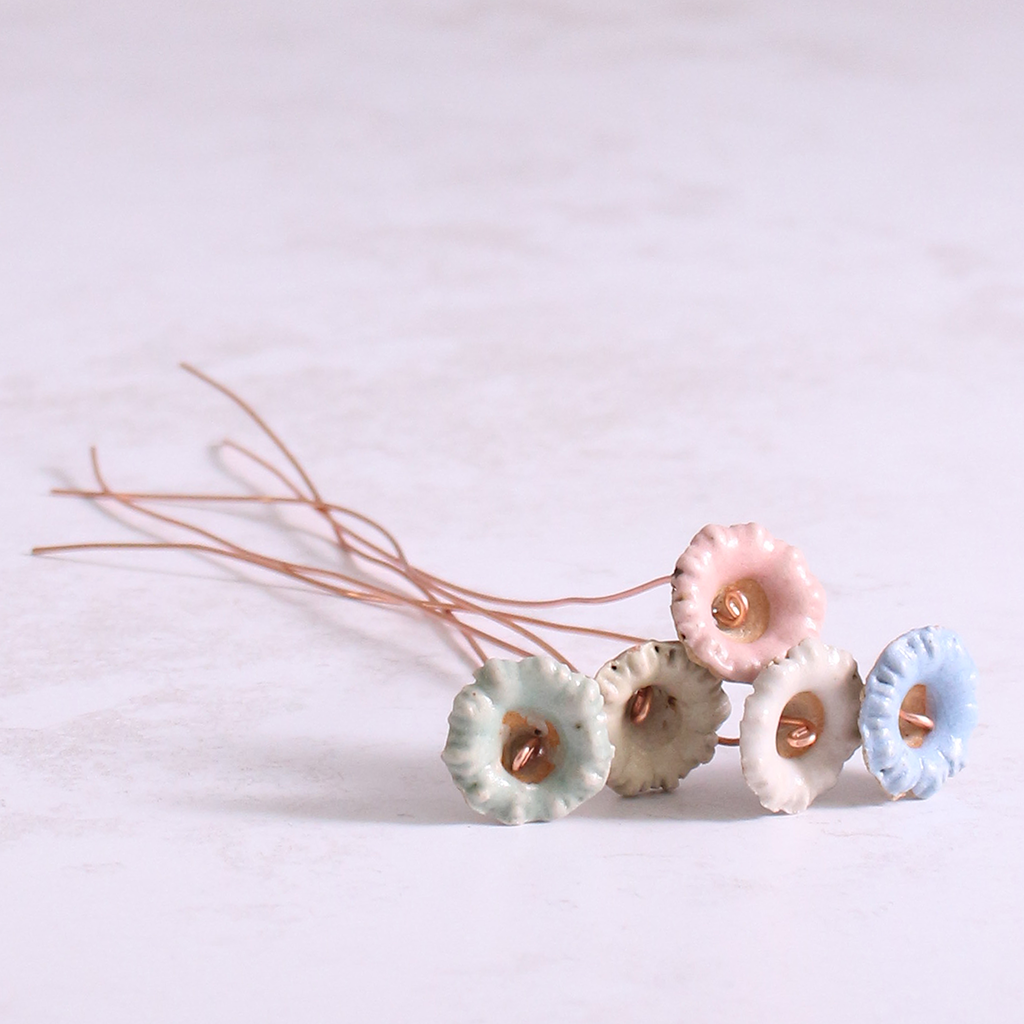 Close up of ceramic wild flower stems beautifully arranged on a table.