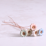 Close up of ceramic wild flower stems beautifully arranged on a table.