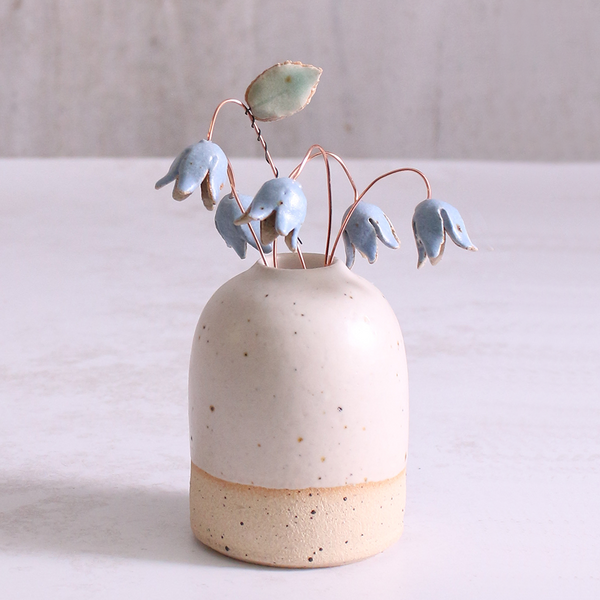Handcrafted ceramic bluebell flower stems with soft glazes displayed in an off-white vase. Each flower features a flexible copper wire stem for easy adjustment.