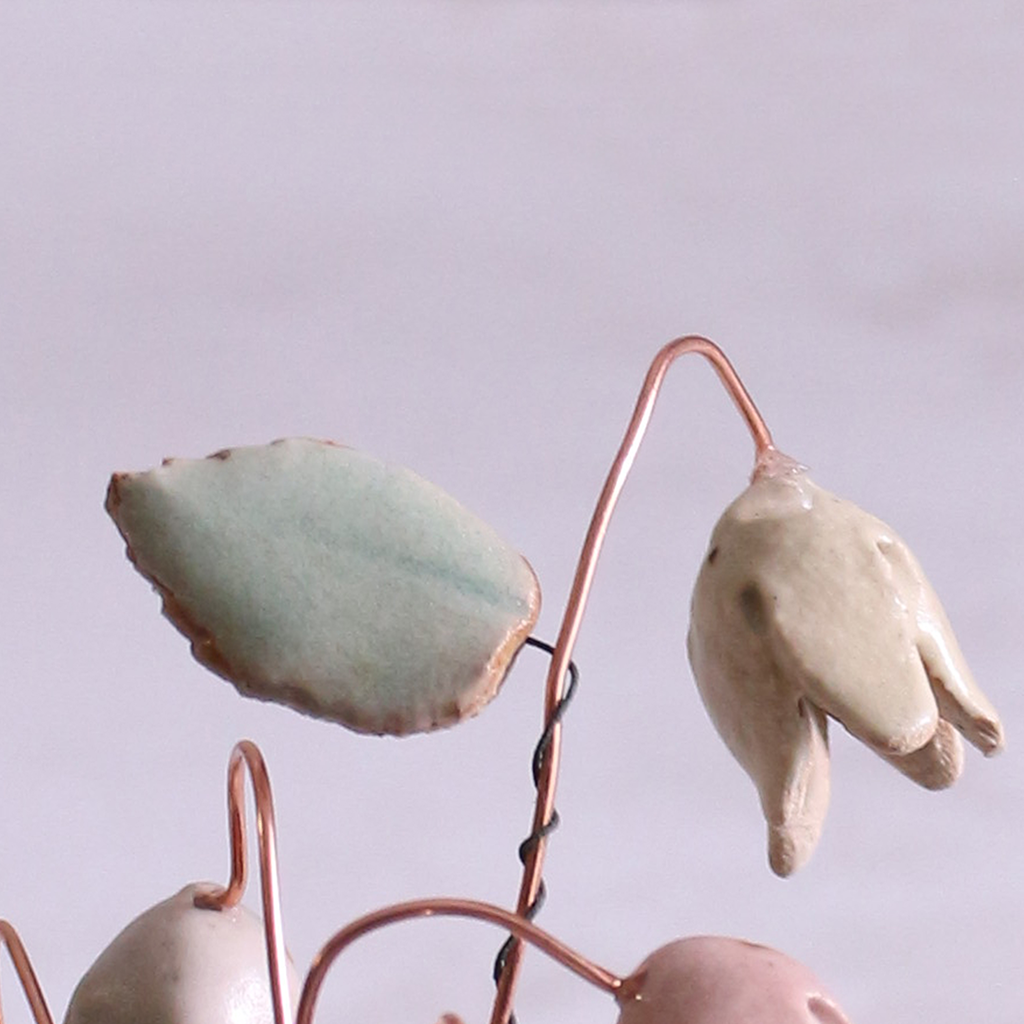 Close-up of pastel ceramic flower stems with ceramic leaves attached, they're on copper wire stems – individually handcrafted floral home accessories from Habulous