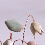 Close-up of pastel ceramic flower stems with ceramic leaves attached, they're on copper wire stems – individually handcrafted floral home accessories from Habulous
