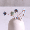 Pastel blue ceramic forget me not flower stems displayed in a handcrafted speckled vase – artisan home décor by Habulous