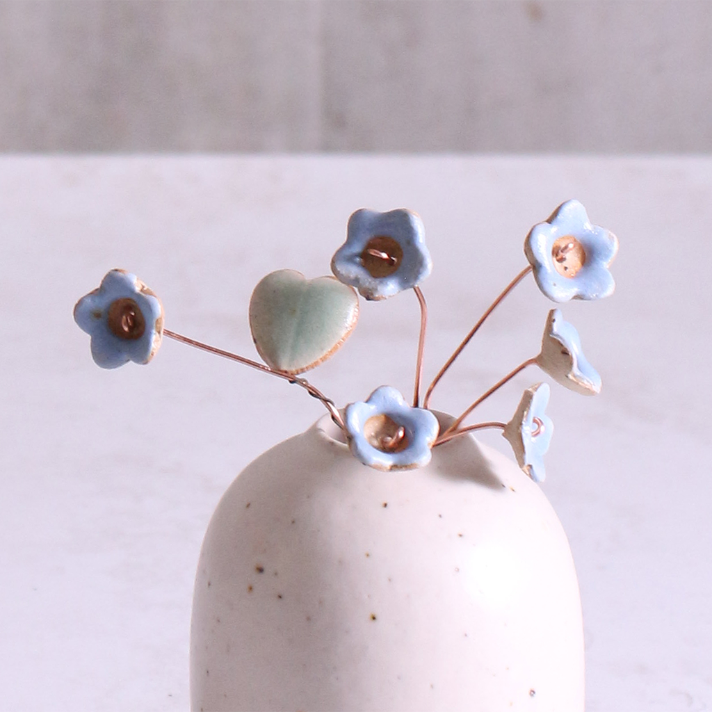 Pastel blue ceramic forget me not flower stems displayed in a handcrafted speckled vase – artisan home décor by Habulous