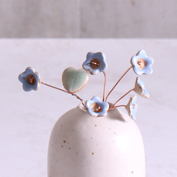 Pastel blue ceramic forget me not flower stems displayed in a handcrafted speckled vase – artisan home décor by Habulous