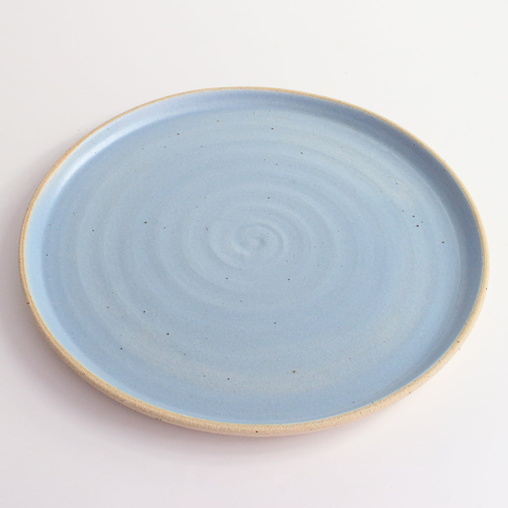 Above view of blue glazed and flecked stoneware of plate
