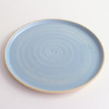 Above view of blue glazed and flecked stoneware of plate