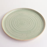 Above view of green glazed and flecked stoneware of plate