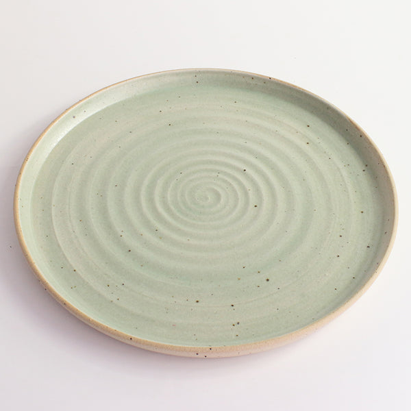 Above view of green glazed and flecked stoneware of plate