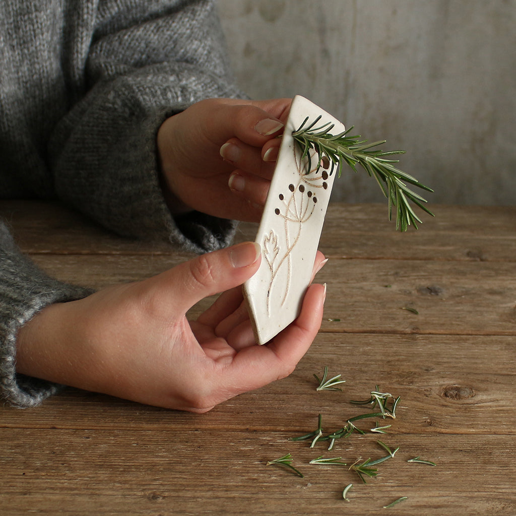 Herbs being stripped through the holes of the marker