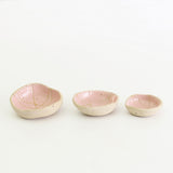 Row of three pink patterned wonky bowls in medium, small and mini sizes